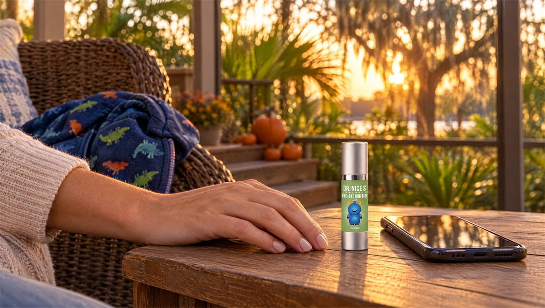 A hand resting beside a small bottle of Dr. Nice's Bye-Bye Bug Bite on a Florida porch table at sunset, pumpkins on the steps