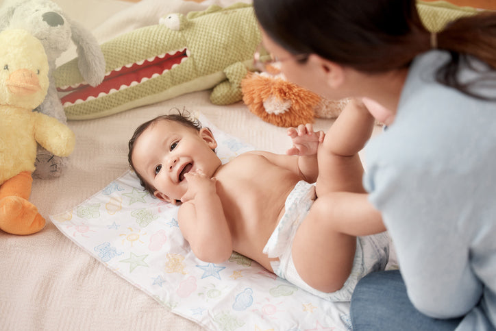 Parent applying Booty Soothe diaper cream to baby’s bottom to prevent rash