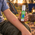 One dot of Bye-Bye Bug Bite on a bug bite at a campsite, bottle in hand